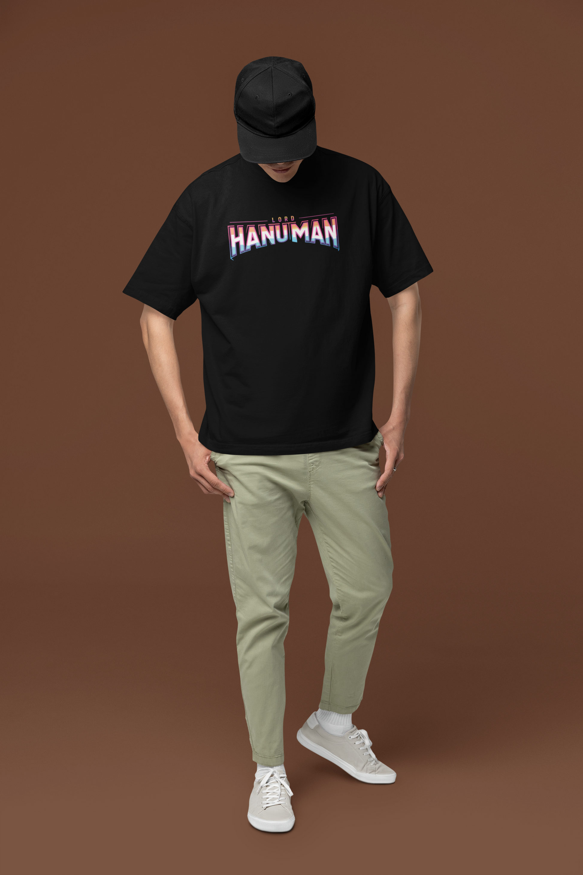 Person wearing a black t-shirt with 'HANUMAN' printed on it against a brown background